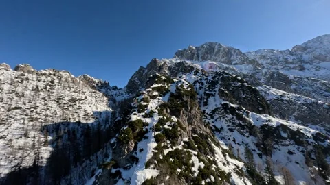 FPV Drone Diving Down Snowy Mountain Peak in Alps, 4K Stock Footage 321152597