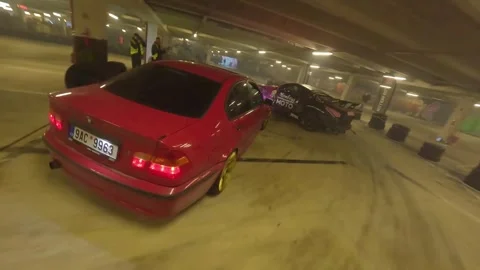 FPV Drone Drift Battle: Red BMW with Flames vs Grey-Pink Nissan 350 Underground Stock Footage 327029707