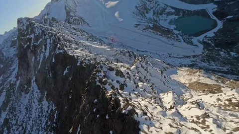 FPV Drone Dynamic Dive Down Snowy Mountain Peak, 4K Stock Footage 321202307