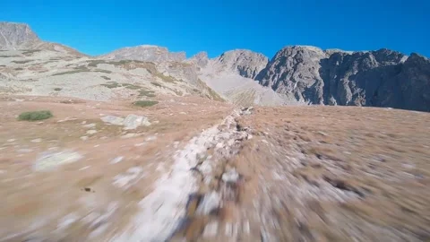 FPV drone fast flying around rocks and people in high rocky mountains Stock Footage 169280523
