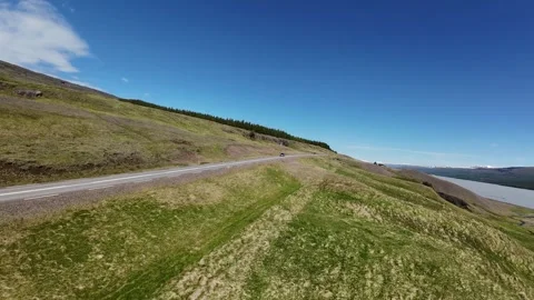 FPV drone flies above a winding road near Egilsstaðir, Iceland, chasing a Stock Footage 331935312