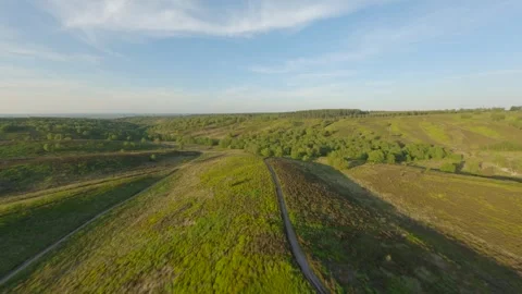 FPV drone flies down ridge of hill towards a valley at sunset Stock Footage 243755156