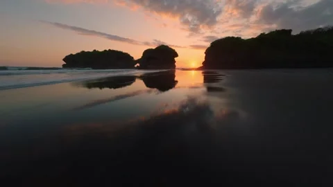 Fpv drone flies over black sand beach at sunset in Bali Stock-Footage 249262920