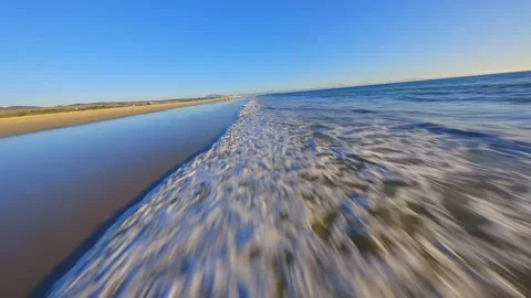 FPV drone flies over the wave on the beach Stock Footage 231031721