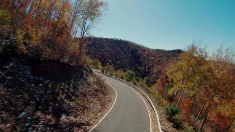FPV drone flies quickly above the road in the autumn mountains.4K stock video Stock Footage 293324056