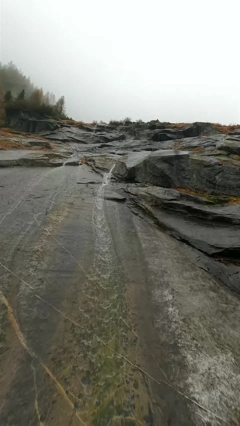 FPV drone flies quickly through the fog close to the stone surface. Austria Stock Footage 301544131