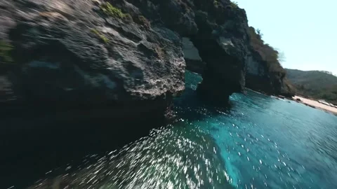 FPV drone flies through the rocks on the beach Stockbeeldmateriaal 269550582