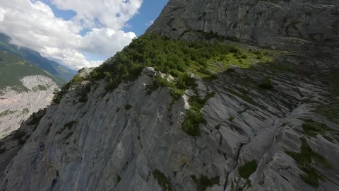 FPV Drone Flight Along Massive Rocky Swiss Mountain Wall Stock Footage 313074051