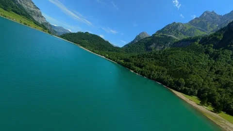FPV Drone Flight Banking Over Turquoise Swiss Alpine Lake 스톡 동영상 340424803
