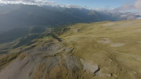 FPV drone flight over alpine meadows above mountain valley Stock Footage 337098468