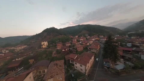 FPV drone flight over Belitsa mountain town and rooftops at sunset in Bulgaria. Stock Footage 343685607