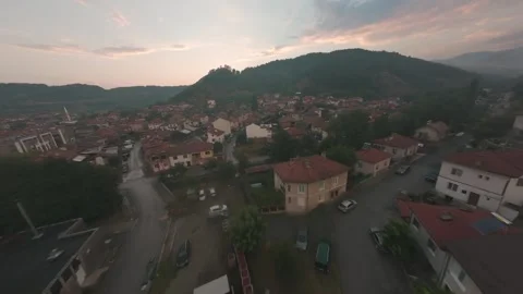 FPV drone flight over Belitsa mountain town and rooftops at sunset in Bulgaria. Stock Footage 343685898
