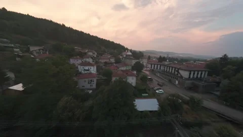 FPV drone flight over Belitsa rooftops approaching Orthodox church at sunset. Stock Footage 343686078
