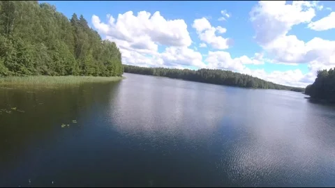 Fpv drone flight over blue lakes in a green forest over water Stock Footage 208609455