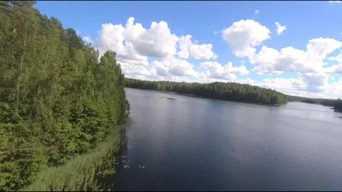Fpv drone flight over blue lakes in a green forest over water Stock Footage 208610045