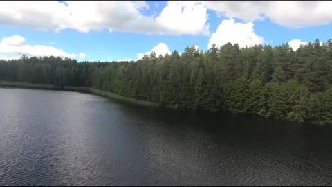 Fpv drone flight over blue lakes in a green forest over water Stock Footage 208610194