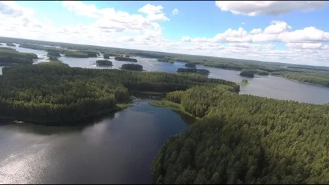 Fpv drone flight over blue lakes in a green forest over water Stock Footage 208610371