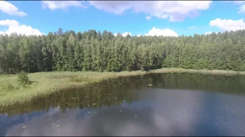 Fpv drone flight over blue lakes in a green forest over water Stock Footage 208610816