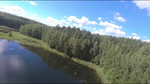 Fpv drone flight over blue lakes in a green forest over water Stock Footage 208611184