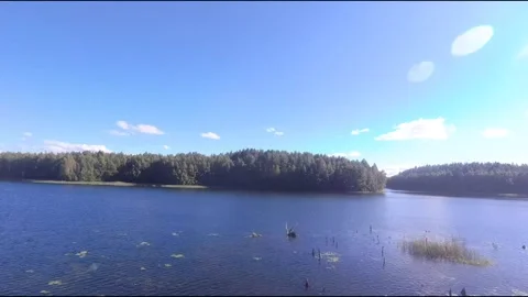 Fpv drone flight over blue lakes in a green forest over water Stock Footage 208612151