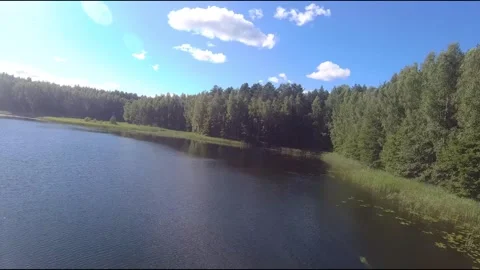 Fpv drone flight over blue lakes in a green forest over water Stock Footage 208612227