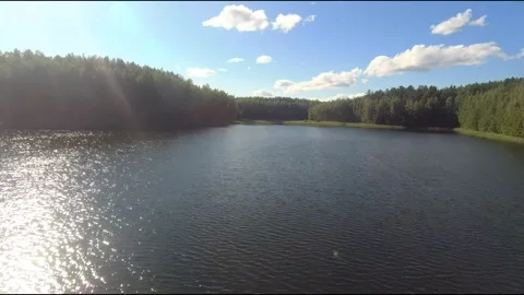 Fpv drone flight over blue lakes in a green forest over water Stock Footage 208612745
