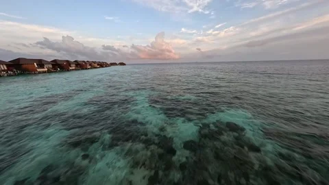 FPV Drone Flight Over Clear Ocean and Water Villas at Sunrise in Maldives Stock Footage 342609364