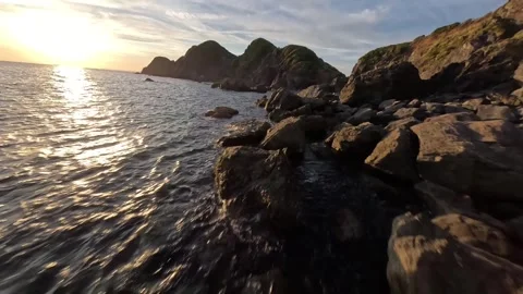 FPV Drone Flight Over Coastal Rocks at Sunset Video stock 335703399