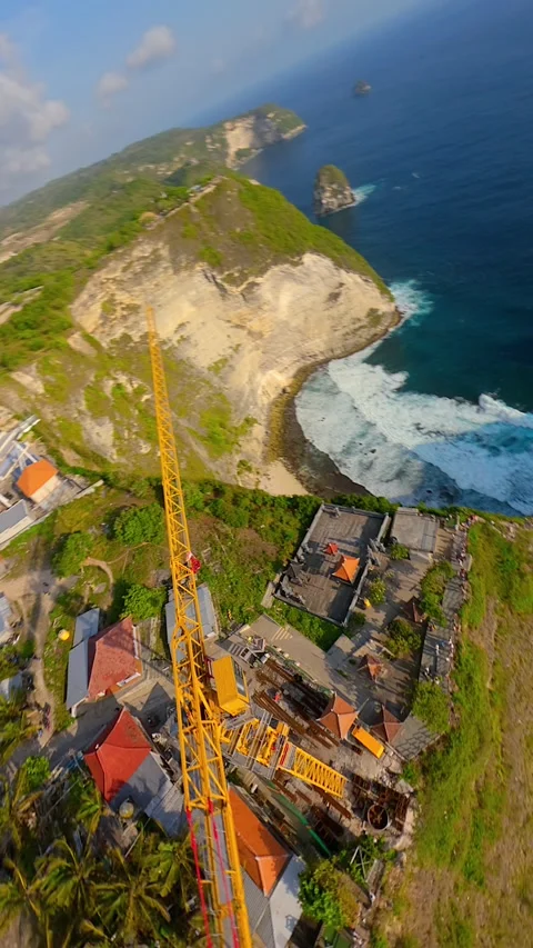 FPV drone flight over construction crane and cliffs at Kelingking Beach, Bali Video stock 322550371