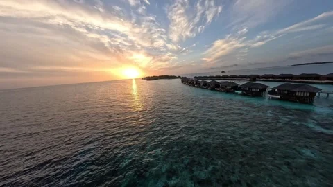 FPV Drone Flight Over Crystal Clear Ocean and Water Villa at Sunrise in Maldives Stock Footage 343541810
