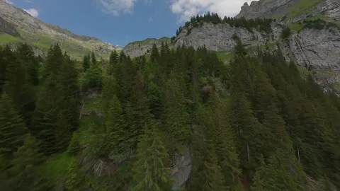 FPV Drone Flight Over Forested Mountain Slope and Rocky Turn Stock Footage 312409894