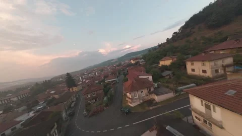 FPV drone flight over rooftops of Belitsa mountain town at sunset in Bulgaria. Stock Footage 343686334