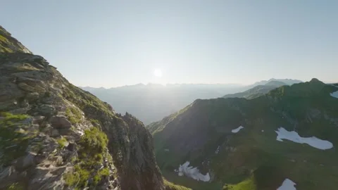 Fpv drone flying along alpine cliff at sunrise Stock Footage 336625085