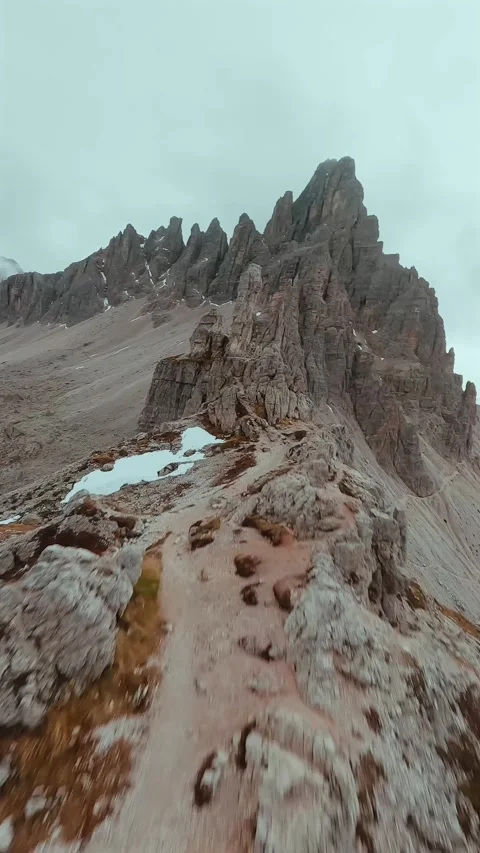 FPV drone flying along the surface of mountain cliffs of Cristallo mountain. Stockbeeldmateriaal 342959903