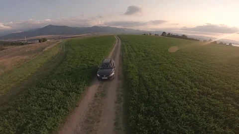 FPV drone flying around a car and drone pilot on a nice green summer meadow Stock Footage 169280490