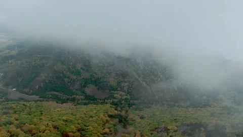 FPV drone flying fast through the clouds, with views of the autumn forest Stock Footage 293324928