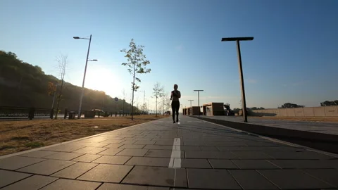 FPV drone flying front view to sporty female athlete wearing sportswear during Stock Footage 224902357