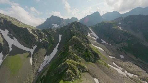 FPV drone flying on high snowy mountain rocky top ridge Stock Footage 330055349