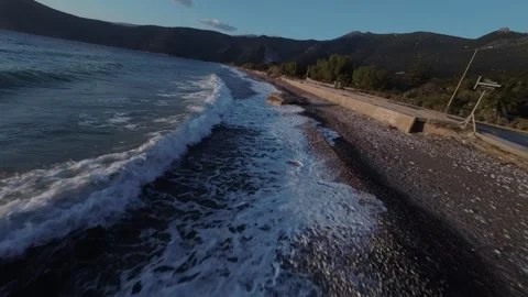 FPV drone flying low along shoreline at dramatic sunset Stock Footage 329588038