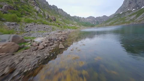 Fpv drone flying low over lake in fjord on a moody day Lofoten Norway Stock Footage 277135693