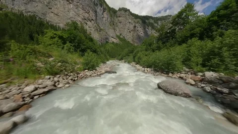 FPV Drone Flying Low Over Mountain River and Under Bridge – Swiss Alps Stock Footage 313004328
