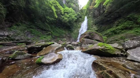 FPV Drone Flying Low Over Water Toward a Tall Waterfall in Nara Japan Video stock 335576253