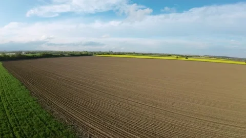 FPV drone flying over freshly plowed agricultural field with green wheat Stock-Footage 240698405