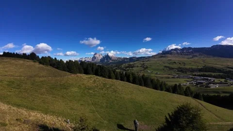 Fpv drone flying over green hills revealing dolomite mountains Stockbeeldmateriaal 328247036