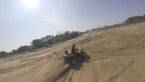 FPV drone is flying over a man riding an ATV on high speed, off-road Stock Footage 139609178