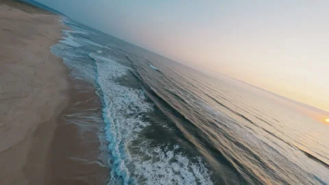 FPV Drone flying over Ocean Waves at Sunset Along Sandy Coastline, Portugal Stock Footage 327441747