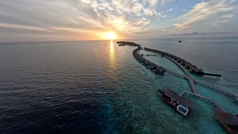 FPV Drone Flying Over the Ocean Near a Water Villa at Sunrise in Maldives Stock Footage 344872052