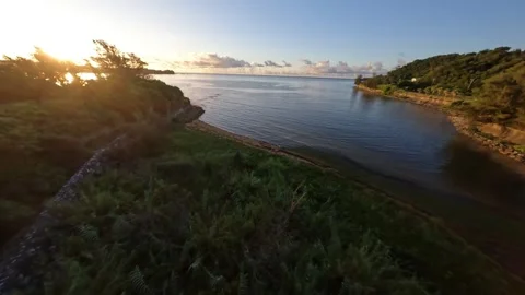 FPV drone flying over Okinawa sea at sunrise, aerial view toward glowing horizon Video stock 331728868