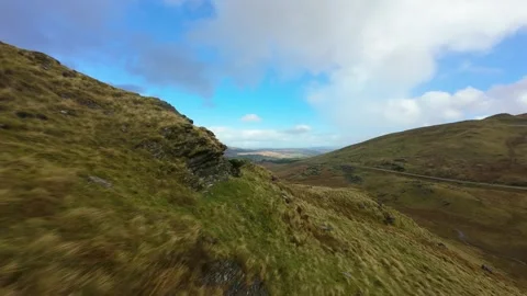 Fpv drone flying over rolling hills and green valleys Stockbeeldmateriaal 327715464