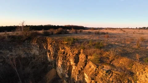 FPV Drone Flying Over Sunlit Cliff at Golden Hour Vidéo 331096169